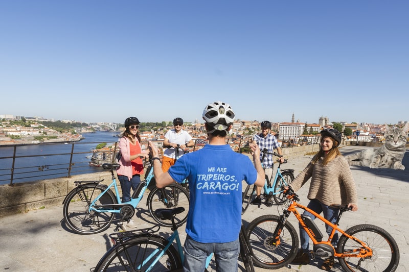 Ciclistas com guia local num miradouro durante o Porto Bike Tour