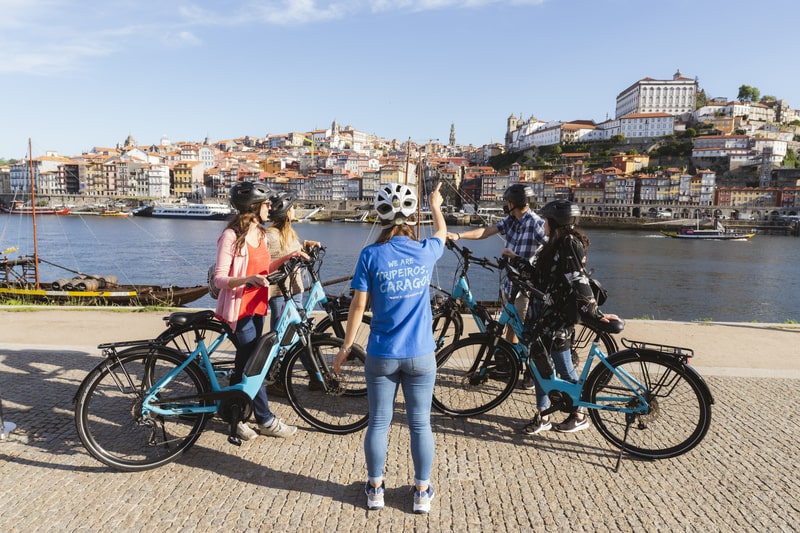 Grupo de ciclistas a desfrutar de um Porto Bike Tour na Ribeira com vista para o rio Douro
