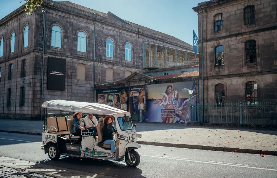 Tuk Tuk passing by the Alfândega do Porto, Portugal
