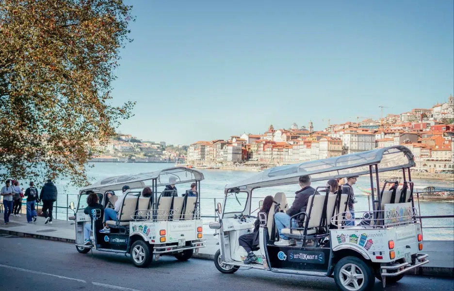Tuk Tuks driving along the Douro riverside in Porto, Portugal