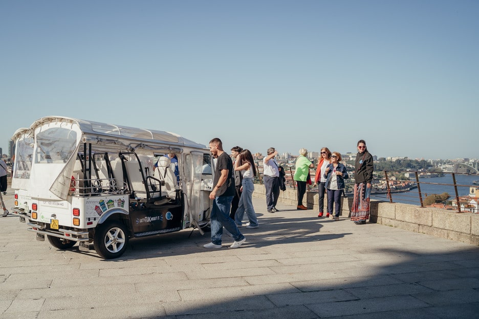 Tuk Tuk parked at a panoramic viewpoint with tourists enjoying the view in Porto, Portuga