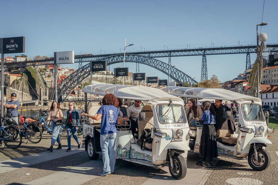 Tuk Tuks turísticos junto al Puente Dom Luís I en Oporto, Portugal