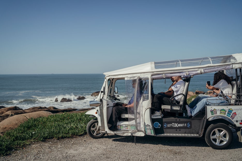 Scenic Tuk Tuk seaside tour with passengers enjoying ocean views