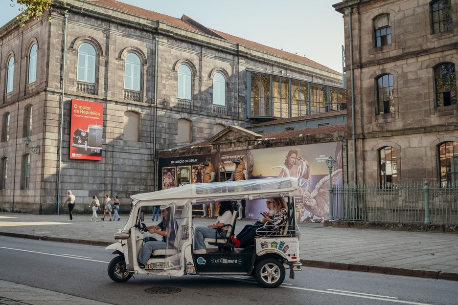 Tuk Tuk passing by the Alfândega do Porto, Portugal