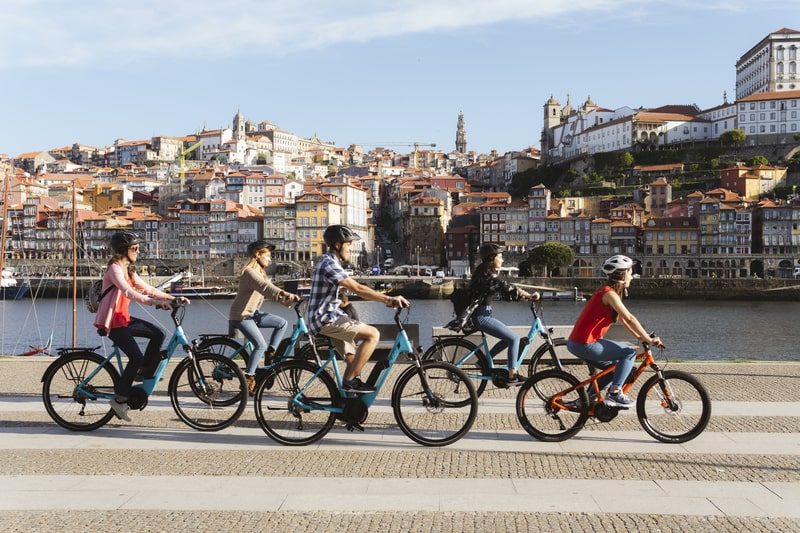 Grupo de ciclistas a pedalar junto ao rio Douro durante o Porto Bike Tour